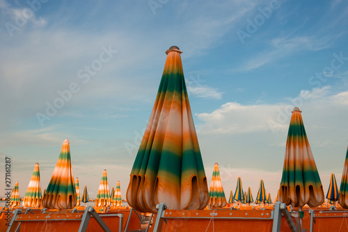 Italian summer on the Adriatic Sea: tyipical italian Riviera Romagnola beach clubs with sunbeds and beach umbrellas with typical vintage colors and look photo