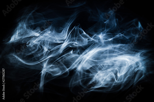 White, blue cigarette smoke on a black background. Stop smoking