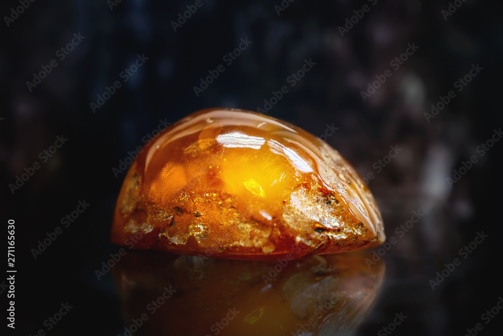 Natural piece of amber on a dark background