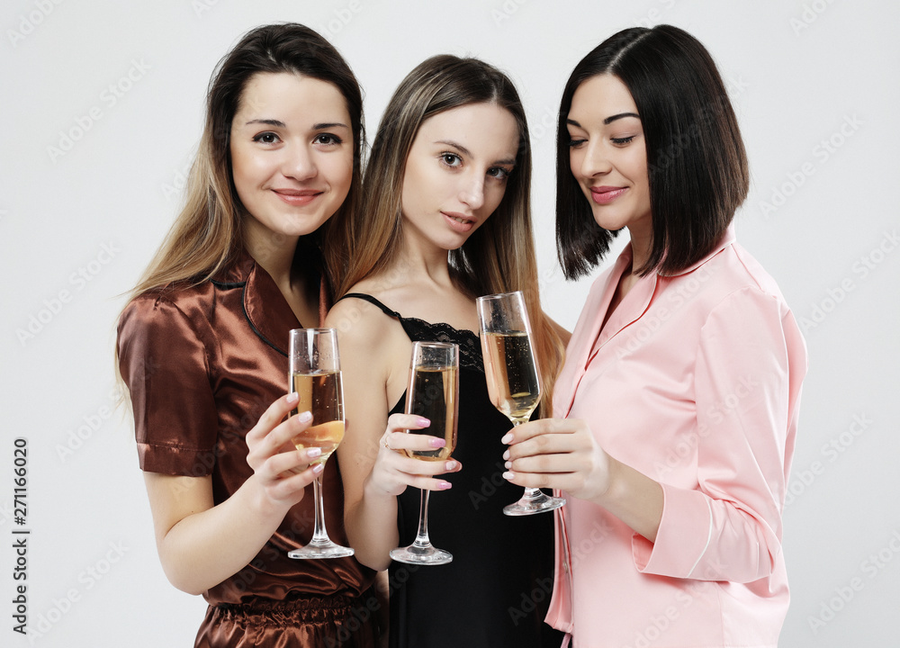 three beautiful girls dressed in pajamas drink champagne and have fun three beautiful girls dressed in pajamas drink champagne and have fun