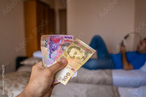 Bundle of Ukrainian money (hryvnia, grivna) in the hands of old man