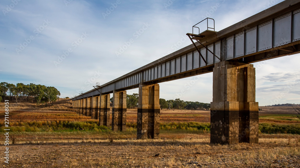 Diminishing perspective view of disused Railway Bridge over Joyces Creek its entry to Lake Cairn Curran on the Moolort Plains near Newstead, Victoria, Australia Diminishing perspective view of disused Railway Bridge over Joyces Creek its entry to Lake Cairn Curran on the Moolort Plains near Newstead, Victoria, Australia