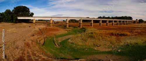 Panoramic view of disused Railway Bridge over Joyces Creek its entry to Lake Cairn Curran on the Moolort Plains near Newstead, Victoria, Australia photo