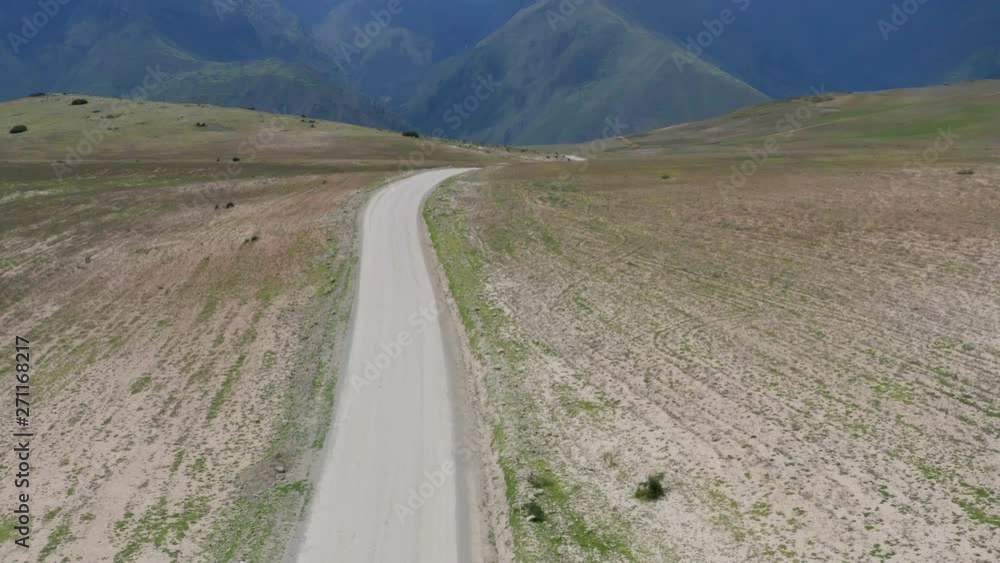 Drone shot flying over a vehicle and tilting up to reveal mountains and storm clouds Drone shot flying over a vehicle and tilting up to reveal mountains and storm clouds
