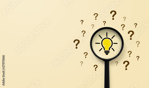 Magnifying glass with light bulb icon and question mark symbol. Concept creative idea and innovation photo