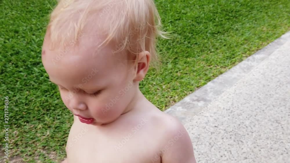 two-year-old blond boy runs along the path, close-up, shakes plump cheeks. slow motion. two-year-old blond boy runs along the path, close-up, shakes plump cheeks. slow motion.