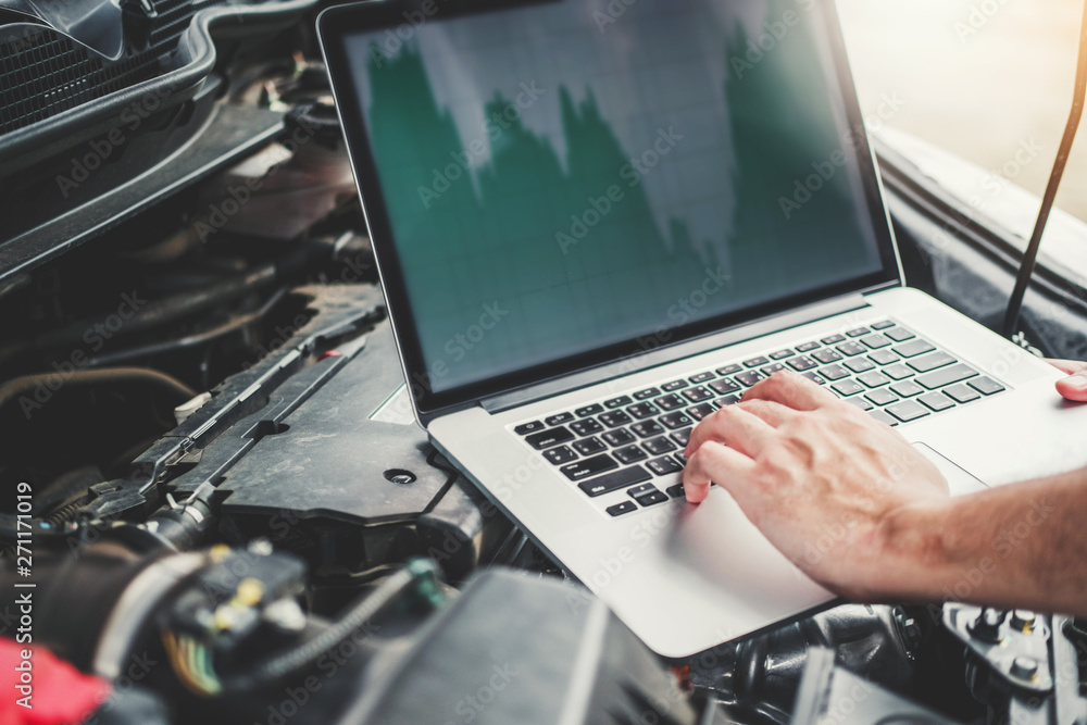 Professional Technician Hands of checking car engine repair service using laptop on car Professional Technician Hands of checking car engine repair service using laptop on car