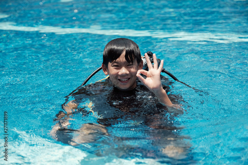 Young little Asian boy scuba diver showing ok hand signal, diving lessons for beginners. Sign Language