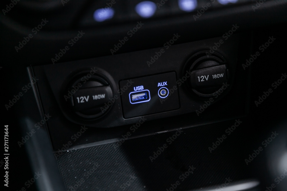 Сlose-up of the car  black interior:  power outlet 12V, USB, AUX and other buttons.