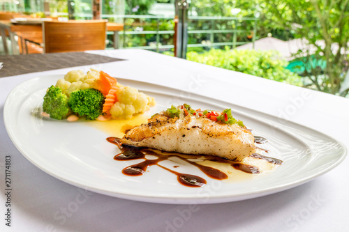 grilled snapper fish steak with vagetable : Healthy lunch grilled snapper fish fillet with fresh salad close-up on a white plate.