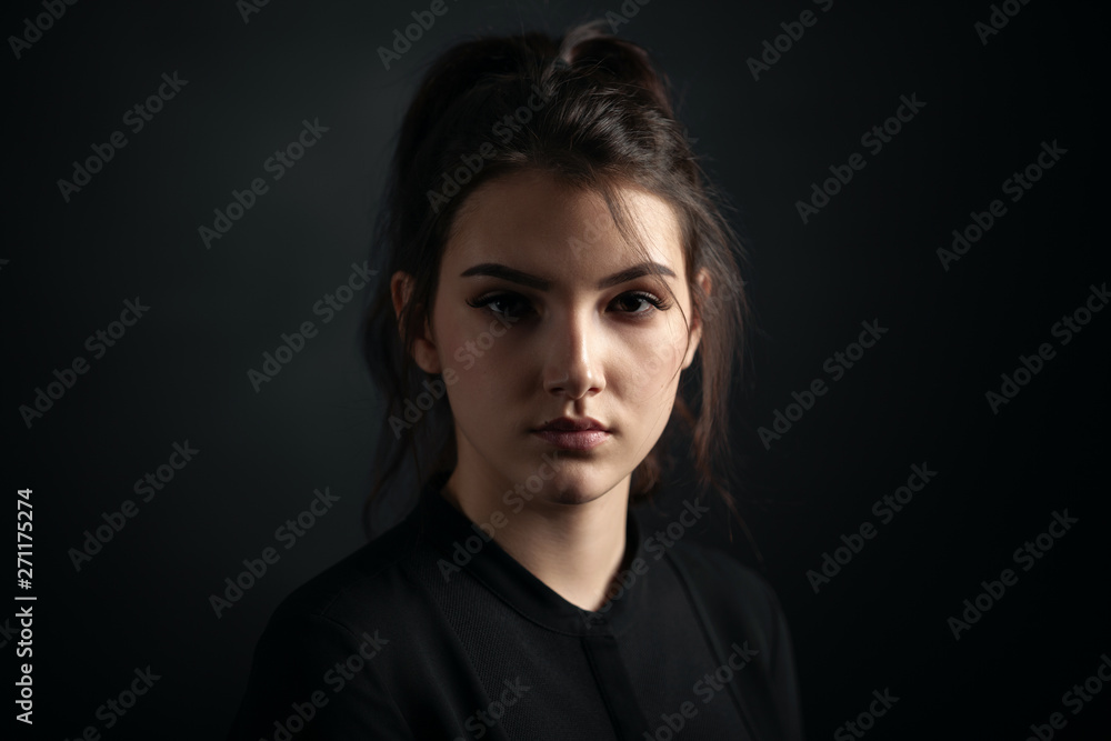 Dramatic portrait of a beautiful girl on a dark background