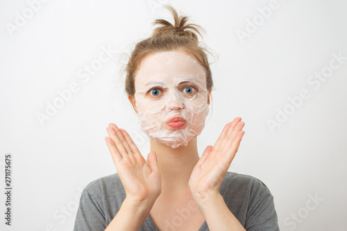 Young caucasian woman with wrinkled white facial mask on her face