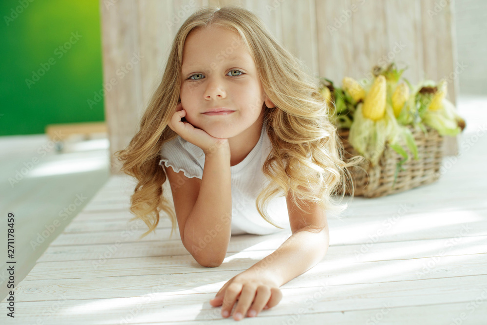 Child with vegetables. Girl holding corn in the hands. Child with vegetables. Girl holding corn in the hands.