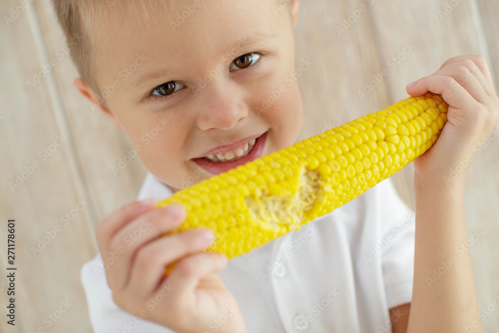 The child eats delicious corn at home The child eats delicious corn at home