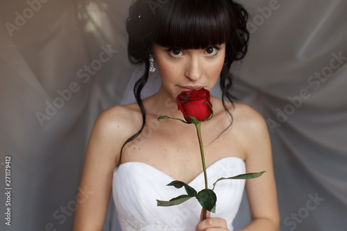 Beauty portrait of bride wearing fashion wedding dress with feathers with luxury delight make-up and hairstyle, studio indoor photo. 