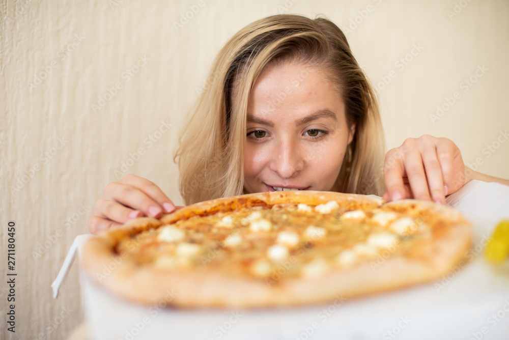 Portrait of a woman eating pizza. Beautiful young woman in black underwear eating pizza