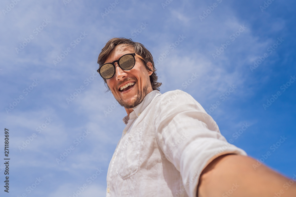 A man takes a selfie against the sky