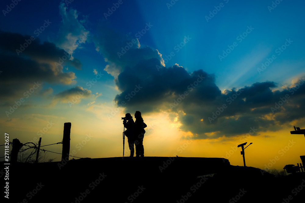 Silhouette of the photographer taking a photo of mountain landscape with sunset, Thailand