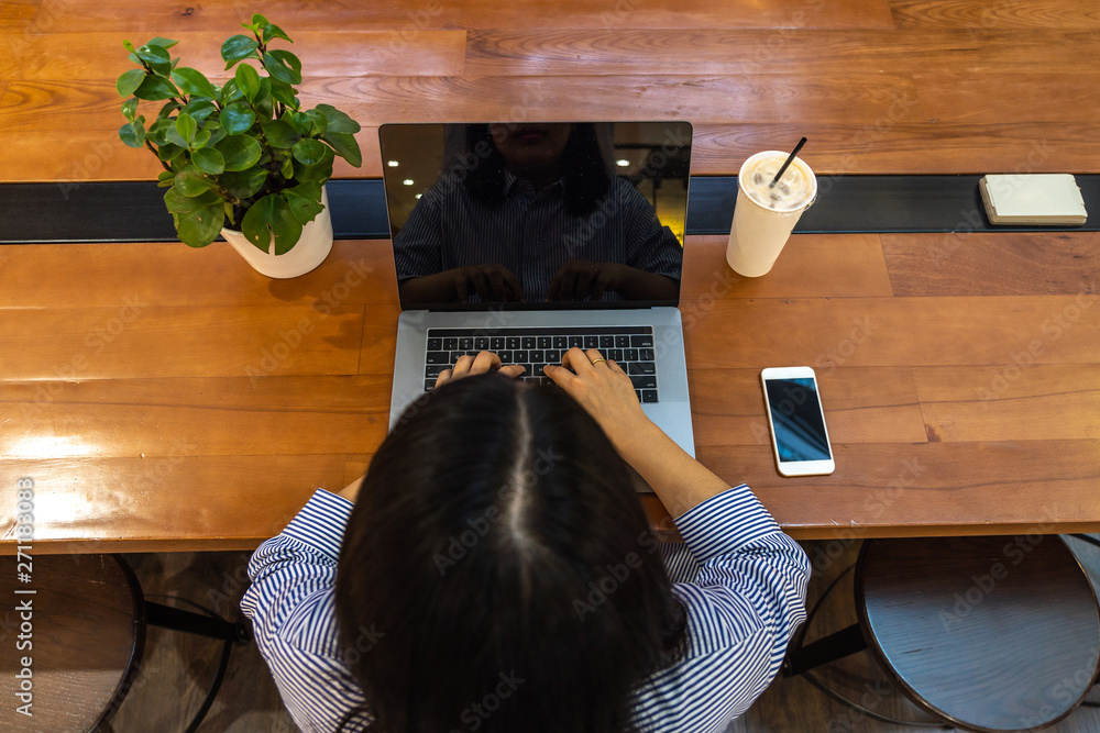 Freelancer using laptop while working on wooden table Freelancer using laptop while working on wooden table