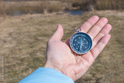 compass in a female hand on a background of nature