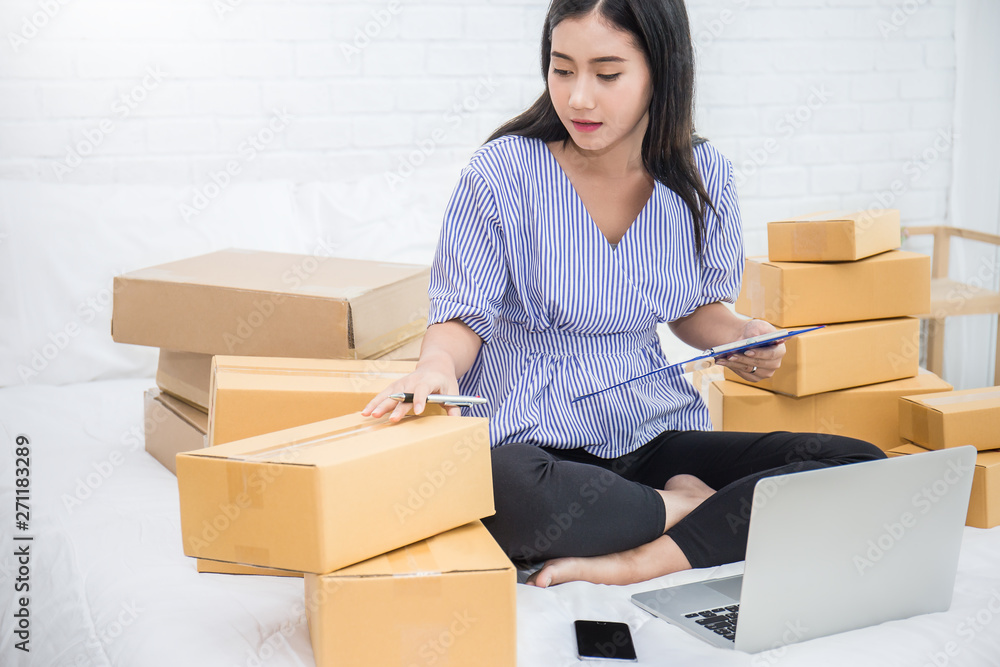 Startup small business entrepreneur SME freelance woman working with computer in bed, Asian small business owner online marketing packing box delivery, SME e-commerce telemarketing freelancer concept Startup small business entrepreneur SME freelance woman working with computer in bed, Asian small business owner online marketing packing box delivery, SME e-commerce telemarketing freelancer concept