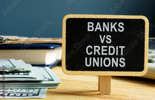 Banks vs Credit Unions concept. Money and ledger. photo