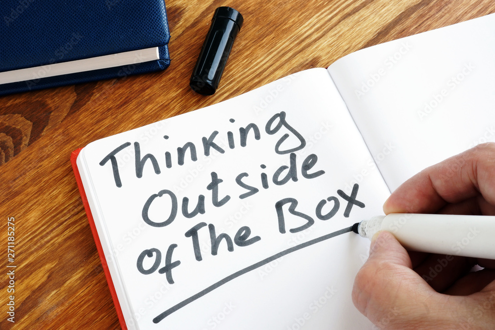 Man is writing Thinking Outside of The Box. Man is writing Thinking Outside of The Box.