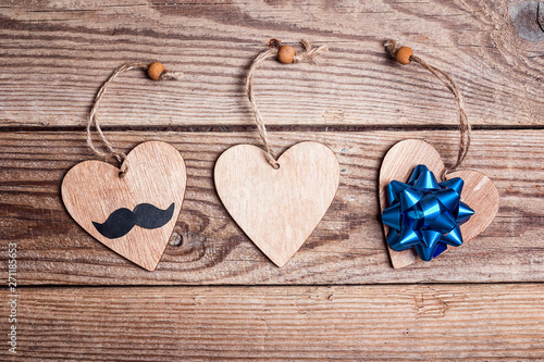 Fathers day concept with hearts, mustache and bow on old wooden table.