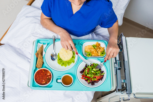 Tray with breakfast for the young female patient. The young woman eating in the hospital. © romaset