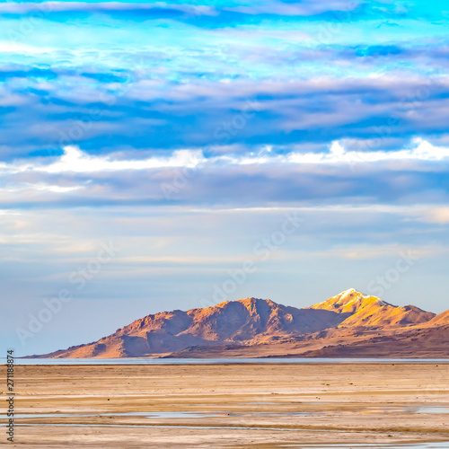 Square Vast sandy shore of a lake under bright blue sky with thick puffy clouds