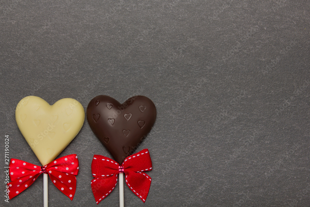 Obraz premium Chocolate candy in the form of hearts on a dark background. Background to Valentine's Day.