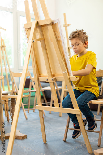 Schoolboy feeling joyful while painting in art school