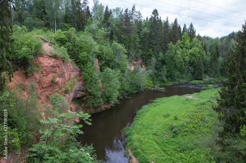 City Straupe  Latvian Republic. Red rocks and river Brasla. Green and overgrown forest. Jun 1. 2019 Travel photo.