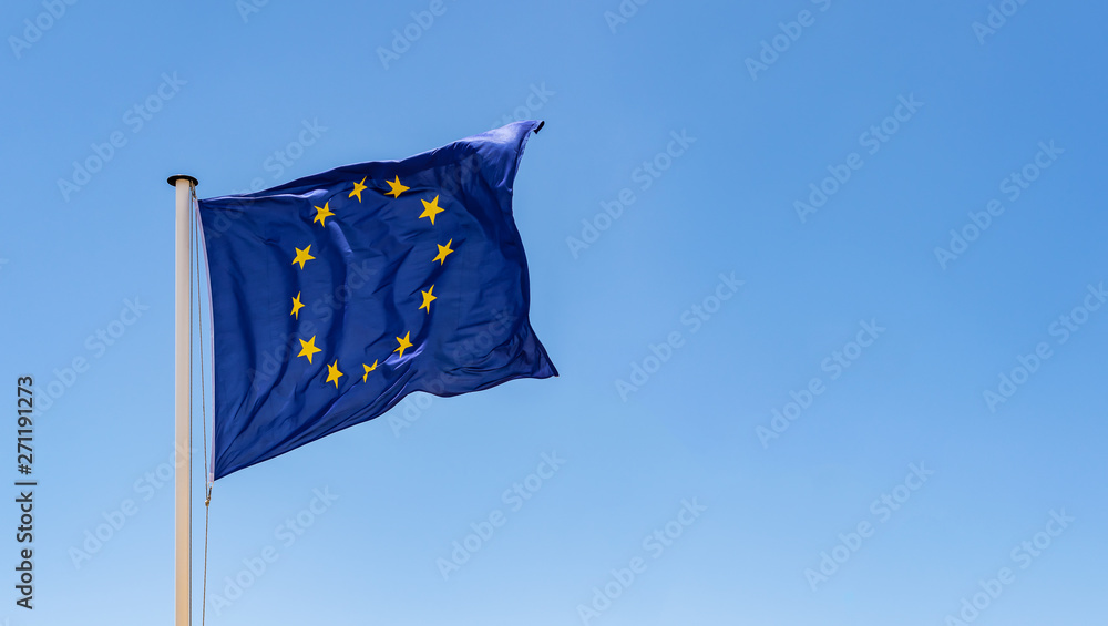 European Union Flag waving in the wind with a clear blue sky background - obrazy, fototapety, plakaty 