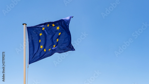 European Union Flag waving in the wind with a clear blue sky background