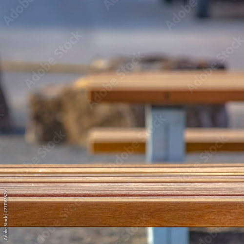 Square Close up of a light brown wooden table with benches at a park
