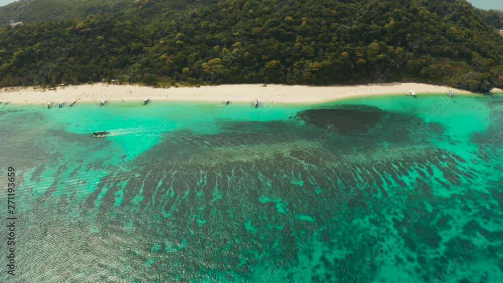Tropical white sand beach, near the blue lagoon and corall reef from above, Boracay, Philippines. Sandy beach with tourists. Summer and travel vacation concept. Tropical white sand beach, near the blue lagoon and corall reef from above, Boracay, Philippines. Sandy beach with tourists. Summer and travel vacation concept.