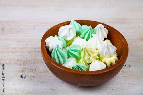 Meringue in white bowl on a wooden background photo