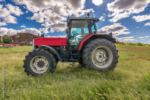 Tractor on a green meadow in spring