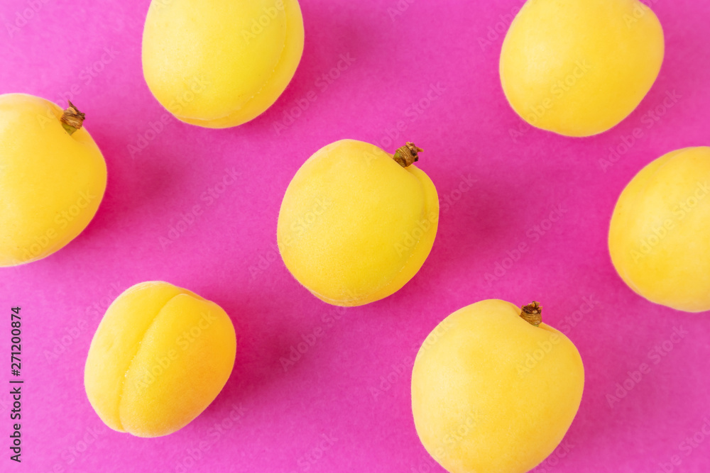 Apricots on a bright pink background. Summer ripe fruit. The concept of growing fruits, natural food rich in vitamins. Minimalism, flat lay, top view, design.