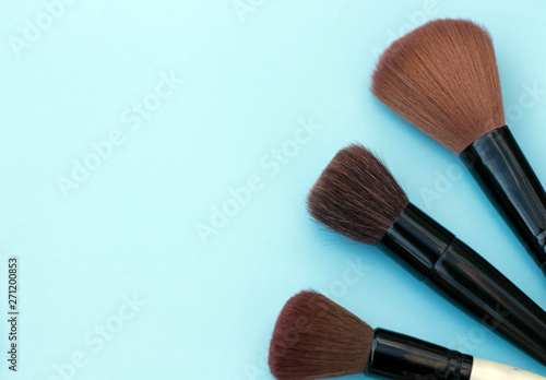 make up brushes blue background copy space