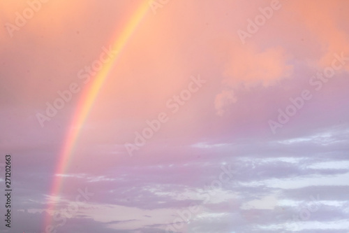 Bright beautiful rainbow on the background of coloured cloudy sry while sunset. Season  summer  phenomenon of nature