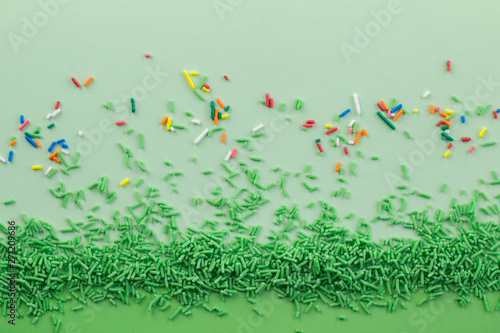 Green sprinkles on two different green tones background with multi coloured sprinkles scattered - Green sprinkle background with space for text