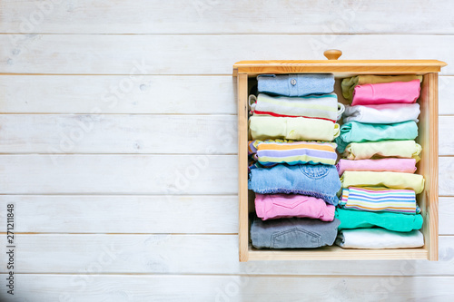 Marie Kondo tyding up method concept - folded kids clothes in pastel colors, copy space photo