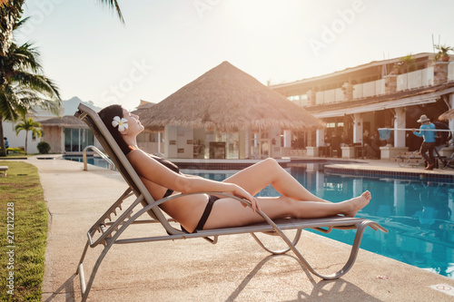 Shot of a young woman relaxing by the luxury pool. Summer vacation. © YURII Seleznov