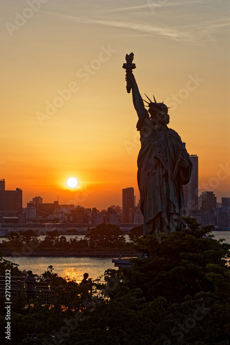 TOKYO, JAPAN, May 17, 2019 : Sunset on Liberty statue in Odaiba. The Greater Tokyo Area is ranked as the most populous metropolitan area in the world.