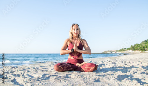 caucasian healthy adult woman with beautiful body doing yoga meditation at sunrise on the beach, yoga poses