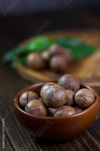 Macadamia nuts in a brown ceramic bowl.