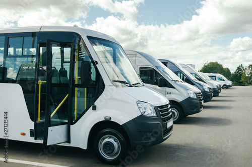 number of new white minibuses and vans outside. photo