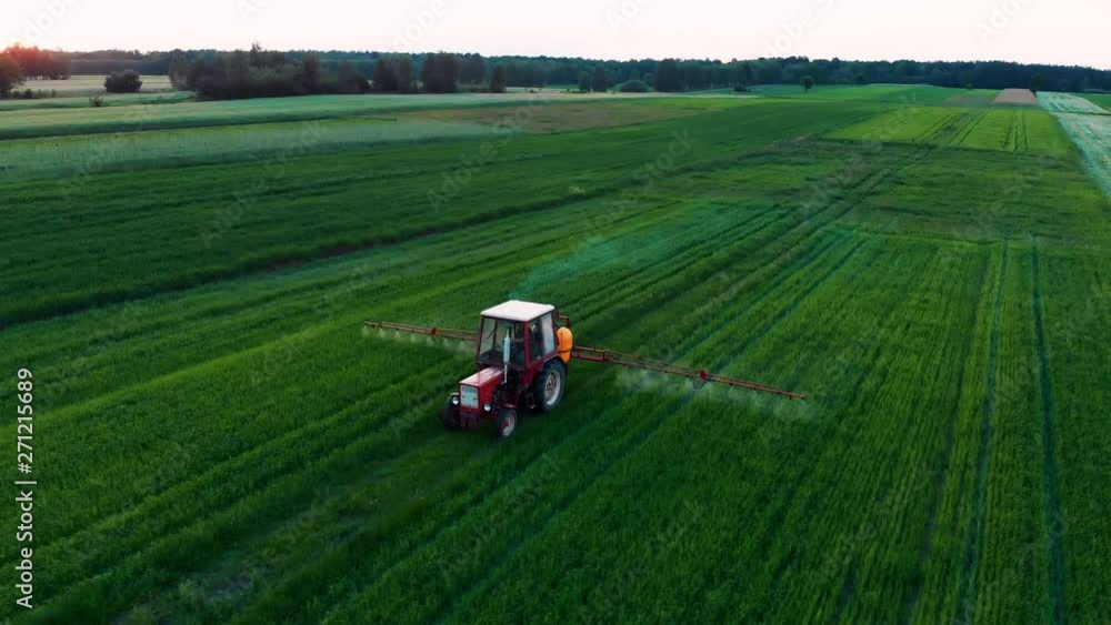 Farming Tractor Vehicle on Agricultural Field Spraying Pesticides Over Crops Aerial 4k Farming Tractor Vehicle on Agricultural Field Spraying Pesticides Over Crops Aerial 4k